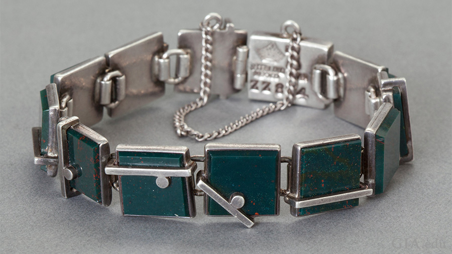 A rare Mexican silver bracelet featuring the March birthstone has bezel set bloodstones in silver, bar and ball overlay links, and is secured with a box clasp and chain. A rare Mexican silver bracelet featuring the March birthstone has bezel set bloodstones in silver, bar and ball overlay links, and is secured with a box clasp and chain.