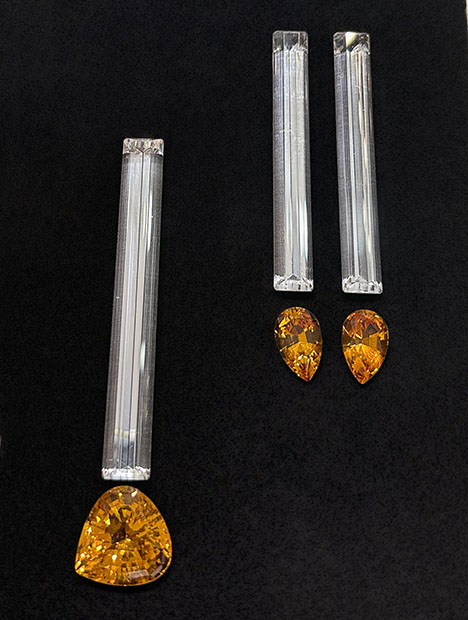 Figure 11. Elongated baguette-cut rock quartz from Brazil (left, 80 × 10 mm, 61.41 ct stone; right, two 70 × 9 mm stones totaling 83.07 carats) accented by Bolivian citrine (left, 25.27 ct triangular brilliant; right, two pear brilliants totaling 15.30 carats). Photo by Jennifer Stone-Sundberg; courtesy of Pillar & Stone International.