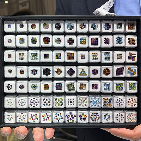 Figure 8. Precision-cut, calibrated gems in a variety of shapes ranging from 1.0 × 1.5 mm baguettes to 4.0 × 6.0 mm lozenges, including amethyst, citrine, tourmaline, topaz, garnet, and peridot, arranged to illustrate various color combinations and patterns. Photo by Jennifer Stone-Sundberg; courtesy of Shanu G. Inc.
