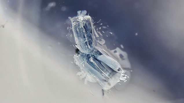 A well-formed aquamarine crystal embedded within colorless quartz. Photomicrograph by Wingtak Lui; field of view 3.2 mm. A well-formed aquamarine crystal embedded within colorless quartz. Photomicrograph by Wingtak Lui; field of view 3.2 mm.