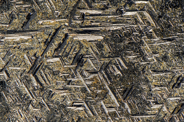 Rutile crystals in a geometric pattern on the surface of hematite. Rutile crystals in a geometric pattern on the surface of hematite.