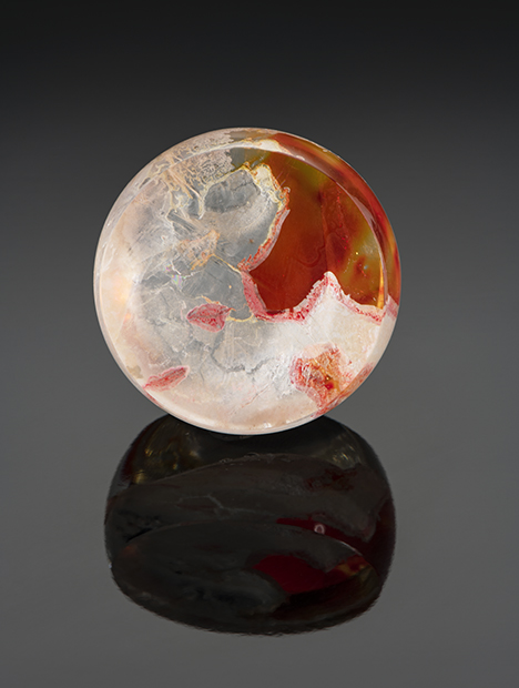 Orange and yellow resin fills fractures in this round quartz tablet.