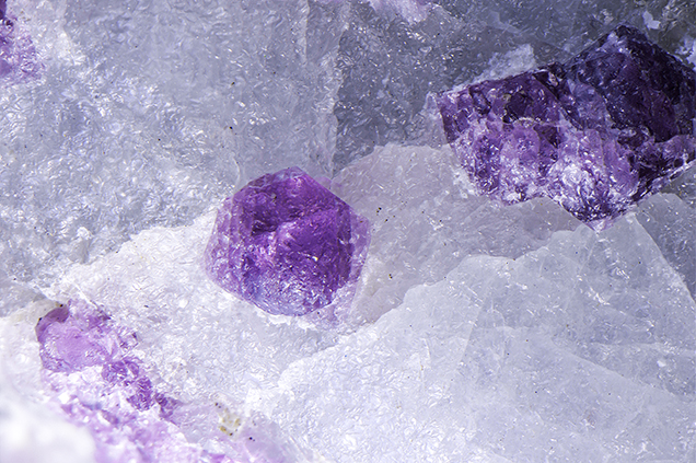Spinel crystals breaking the surface of the light blue sapphire.