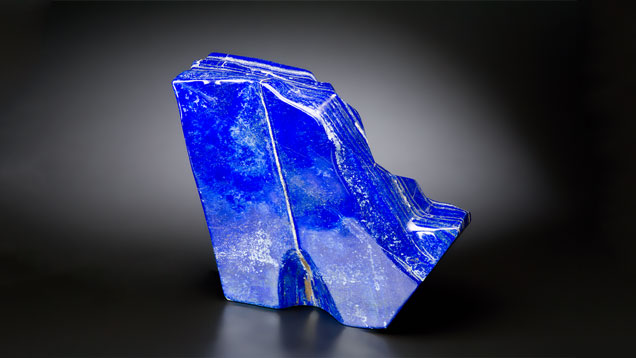 青金石 — 几种矿物质的聚晶（主要是天青石、方解石和黄铁矿）— 尺寸往往很大，例如这块产自阿富汗的 22 英寸高的自由形状样品。 摄影：Kevin Schumacher（凯文·舒马赫）/GIA
