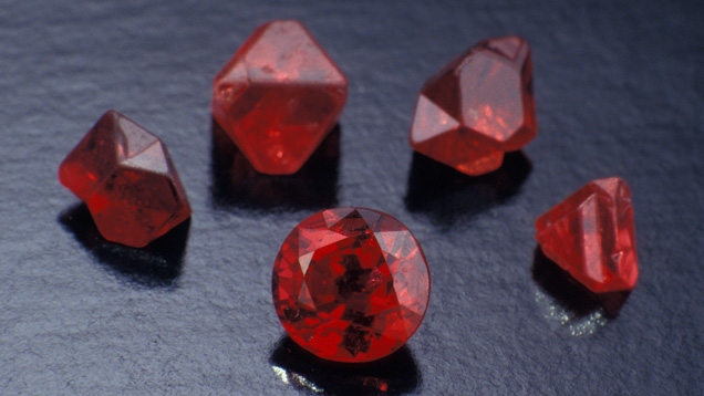 Fashioned and Rough Spinel. The fashioned spinel is from Sri Lanka, while the rough crystals are from Myanmar. The second crystal from the right is an octahedron. The other crystals rotated during growth and appear flattened. Scientists call them twinned crystals.