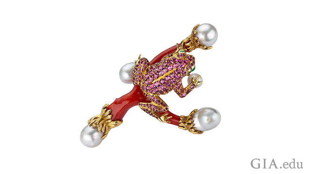 A toad made from pink tourmaline sits on a branch of coral with pearls at the ends of the branches. A toad made from pink tourmaline sits on a branch of coral with pearls at the ends of the branches.