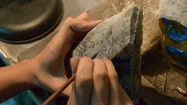 Artist draws design on rough jadeite Artist draws design on rough jadeite