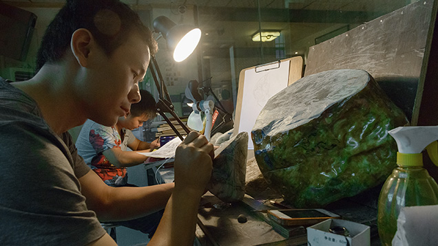 Artist marking up jade for carving Artist marking up jade for carving