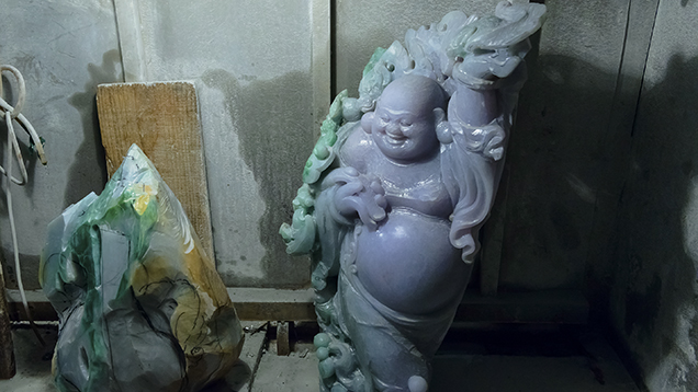 Jadeite carving at beginning stage alongside finished Buddha carving Jadeite carving at beginning stage alongside finished Buddha carving