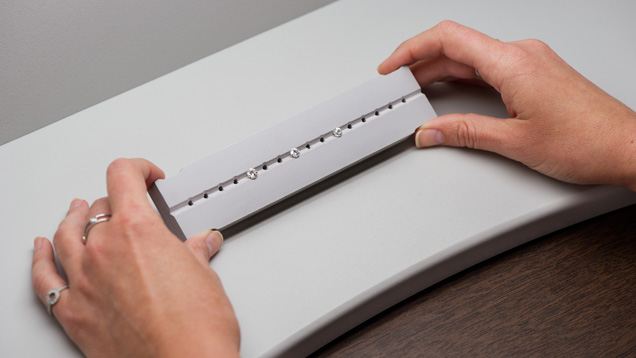 Close-up of hands holding a tray with three diamonds to observe in Diamond Dock. Close-up of hands holding a tray with three diamonds to observe in Diamond Dock.