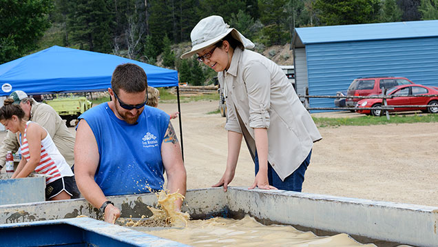 Man teaching woman how to wash sapphire gravel Man teaching woman how to wash sapphire gravel