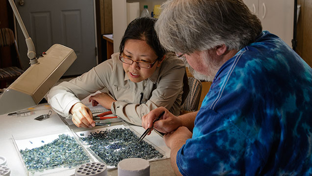 Man and woman checking sapphire colors Man and woman checking sapphire colors