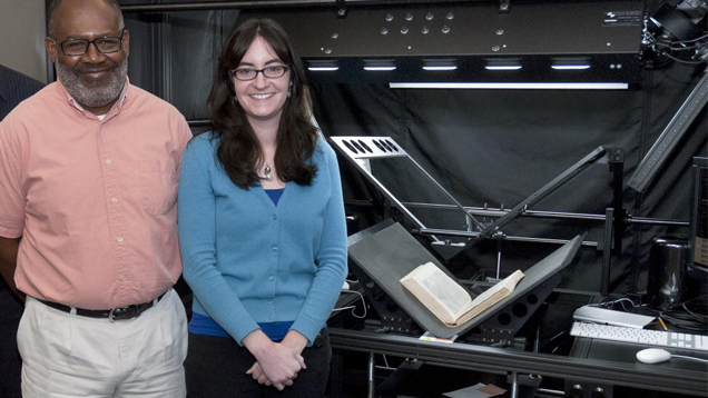 Two research librarians stand in front of the high-tech book scanner. Two research librarians stand in front of the high-tech book scanner.