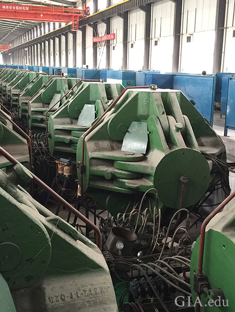 A row of HPHT synthetic diamond presses machinery in a large factory. A row of HPHT synthetic diamond presses machinery in a large factory.