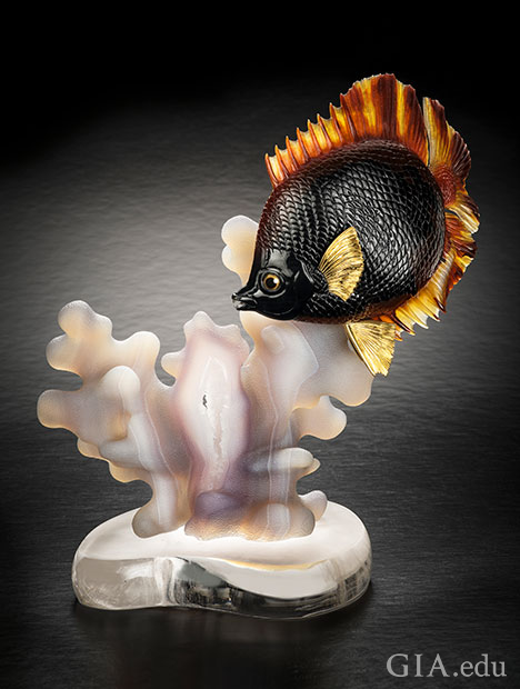 A fish “swims” above a piece of coral. A fish “swims” above a piece of coral.