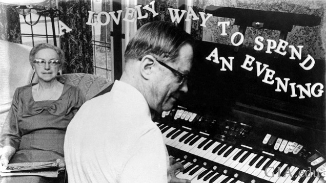 A woman sits and listens as a man plays an organ. A woman sits and listens as a man plays an organ.