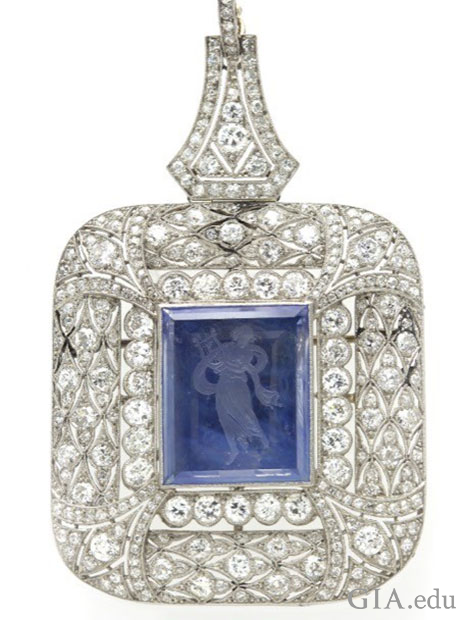 A square shaped pendant with a center reverse intaglio sapphire that is surrounded by diamonds. A square shaped pendant with a center reverse intaglio sapphire that is surrounded by diamonds.