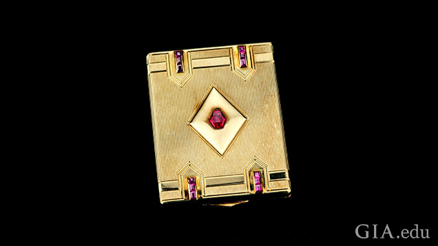Gold compact embellished with synthetic rublies.