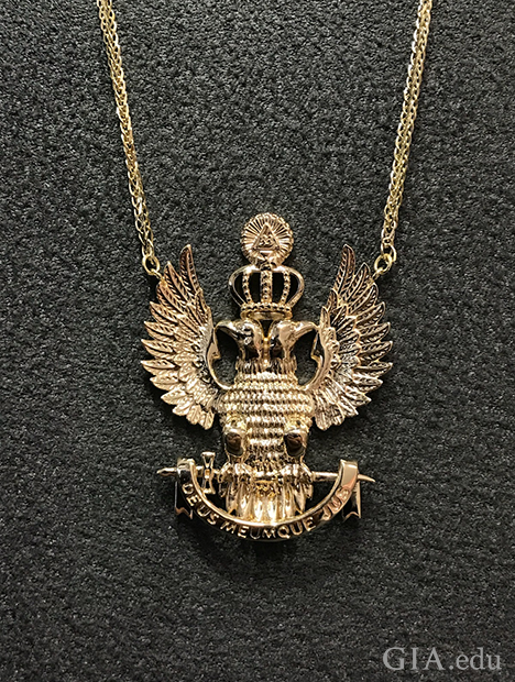 The pendant is in the form of two eagles sitting back to back, with wings spread and a crown on their heads. The pendant is in the form of two eagles sitting back to back, with wings spread and a crown on their heads.