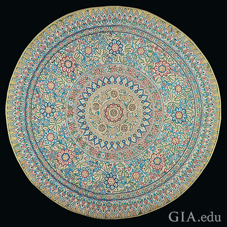 Thousands of natural pearls are set in geometric patterns on a round cloth, similar to a mandela.
