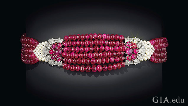 A ruby and diamond choker. The center section is made of six strands of red pearls, framed by rubies and diamonds.