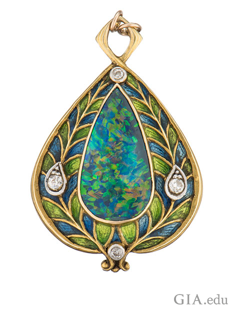 A pear shaped black opal cabochon is enhanced by European-cut diamonds and blue and green enamel applied on 14k gold gold.