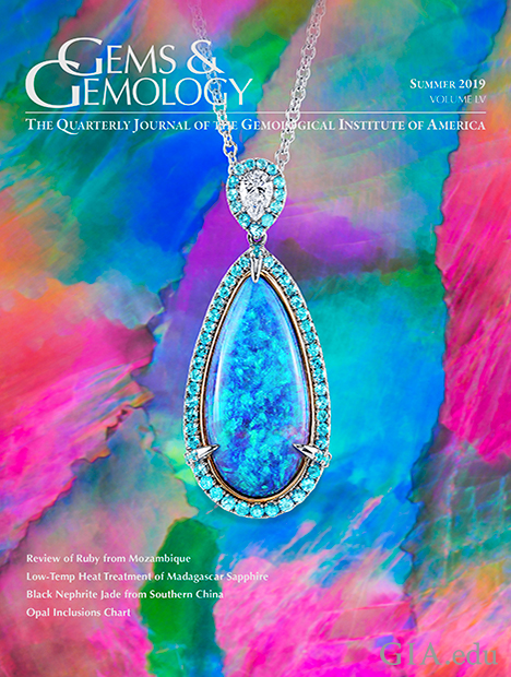 A black opal pendant, accented by pear-shaped diamonds and round Paraíba tourmalines, sits on a photomicrograph of a black opal from Lightning Ridge, Australia, that shows broad, angular flashes of play-of-color known as a harlequin or mosaic pattern. A black opal pendant, accented by pear-shaped diamonds and round Paraíba tourmalines, sits on a photomicrograph of a black opal from Lightning Ridge, Australia, that shows broad, angular flashes of play-of-color known as a harlequin or mosaic pattern.