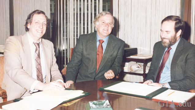 Three men at a conference table. Three men at a conference table.