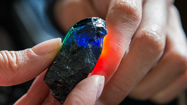 Hands holding a piece of sapphire rough Hands holding a piece of sapphire rough