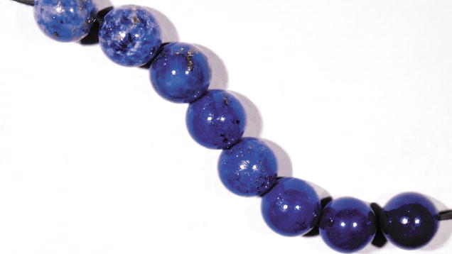 Lapis Lazuli. This collection of beads shows the range of lapis quality, from a pale blue with an excess of calcite or pyrite to a dark blue to violetish blue without visible calcite. Top-quality lapis can contain some pyrite. – Alan Jobbins