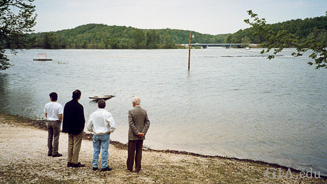 Four men on a riverbank