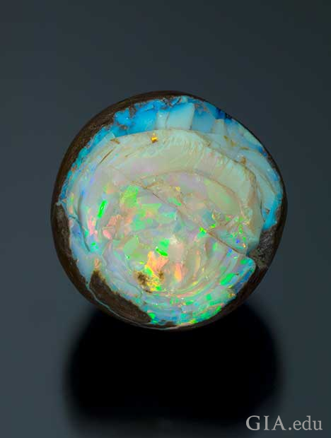 A front-facing piece of rough opal with the edges of its matrix showing. A front-facing piece of rough opal with the edges of its matrix showing.