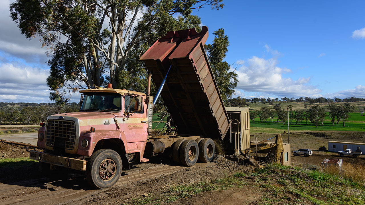 8_189090-1280x720.jpg. A truck loaded with sapphire-bearing clay feeds the washing plant. Two trucks work at the same time. Extra material is stockpiled near the washing plant for future processing. Photo by Vincent Pardieu/GIA.