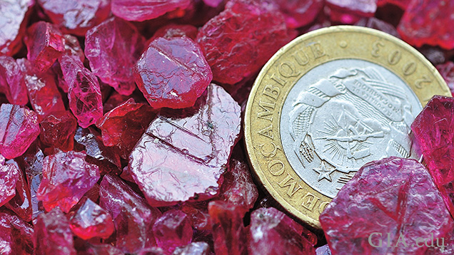 A pile of rough of rubies with a coin for perspective. A pile of rough of rubies with a coin for perspective.