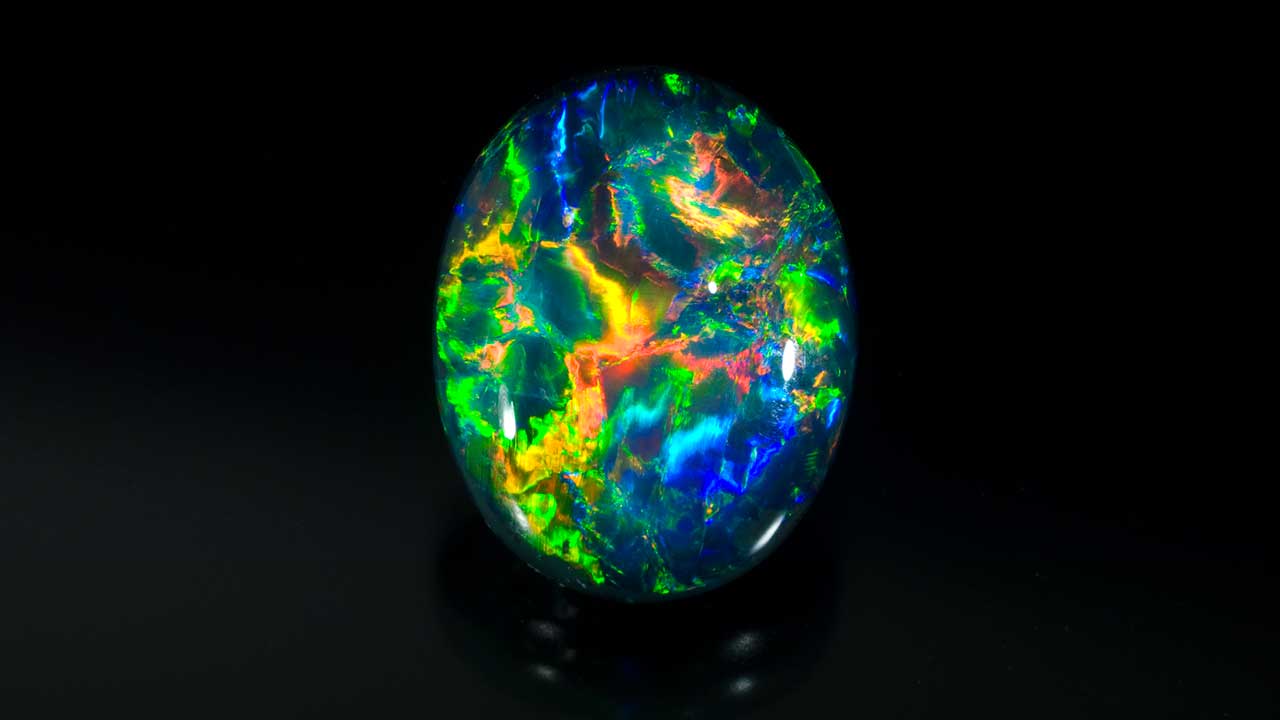 Black-Opal-68470-1280x720.jpg. Black opal can show a rainbow of colors. Photo by Robert Weldon/GIA, courtesy Richard Krementz Gemstones.