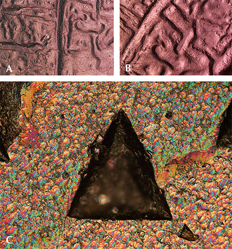 Channels on the surface of a “color-change” pyrope garnet rough under diffused reflected lighting Channels on the surface of a “color-change” pyrope garnet rough under diffused reflected lighting