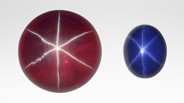 A large synthetic star ruby, left, and smaller synthetic star sapphire. A large synthetic star ruby, left, and smaller synthetic star sapphire.