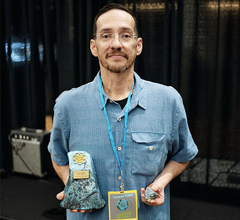 Figure 2. Mark Baca (American Turquoise Online) holds his winning piece (right) and trophy for Best in Show. Photo courtesy of the Turquoise Museum.