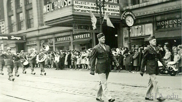 Soldiers and a band marches on a retail street. Soldiers and a band marches on a retail street.