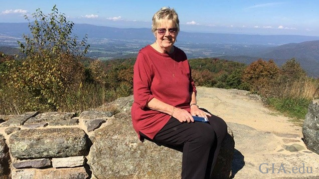 A woman sits on some rocks with a Smokey Mountain vista behind her. A woman sits on some rocks with a Smokey Mountain vista behind her.