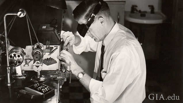 A man works at a jeweler’s bench. A man works at a jeweler’s bench.
