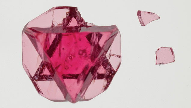 These thin crystals break easily. Figure 2. The Star of David spinel hosts some interesting multiphase inclusions. Such fractured, thin crystals are very brittle; this one was damaged during the cleaning process. Photo by Sasithorn Engniwat/GIA.