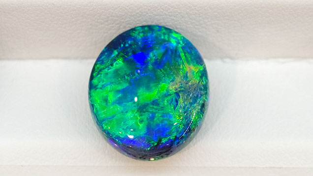 SP17-GNI-fig21_215157-636x358.jpg. Black opal cabochon from Lightning Ridge