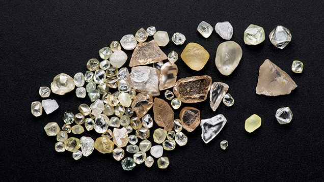 Diamond crystals from the Jequitinhonha River, Brazil. Figure 8. Crystals such as this group from the Jequitinhonha River were once used as markers in card games, as they were not recognized as diamonds. Photo by Robert Weldon/GIA, courtesy of Gar Mineração.
