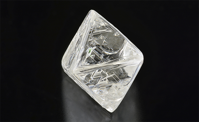 Bright green chromium diopside inclusion in diamond octahedron. Bright green chromium diopside inclusion in diamond octahedron.