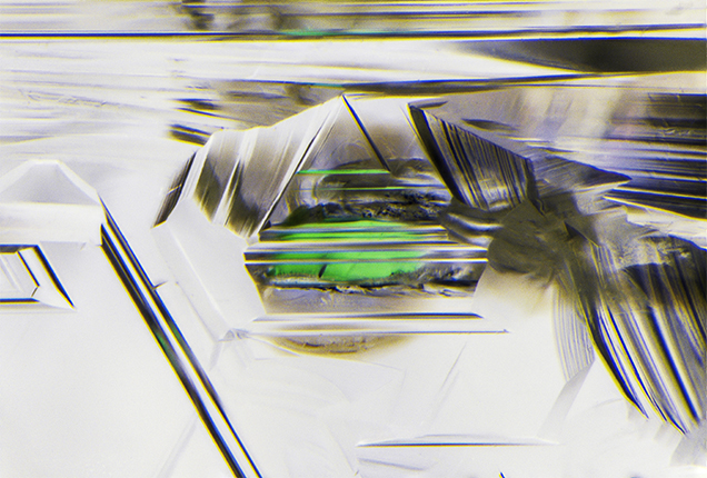 Rounded, etched chromium diopside inclusion in diamond. Rounded, etched chromium diopside inclusion in diamond.