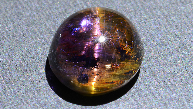 This cabochon displays an unusual yellowish chatoyancy. This cabochon displays an unusual yellowish chatoyancy.