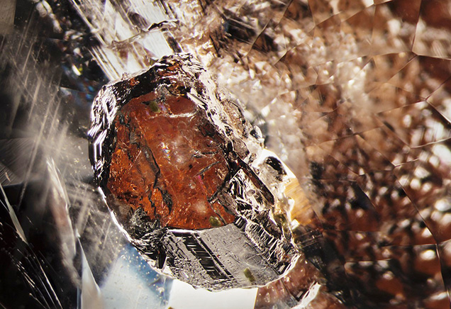 Dark orange triplite inclusion in beryl. Dark orange triplite inclusion in beryl.