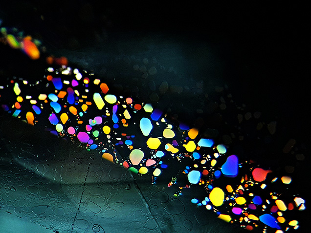 Thin-film fluid inclusions in aquamarine display interference colors. Thin-film fluid inclusions in aquamarine display interference colors.