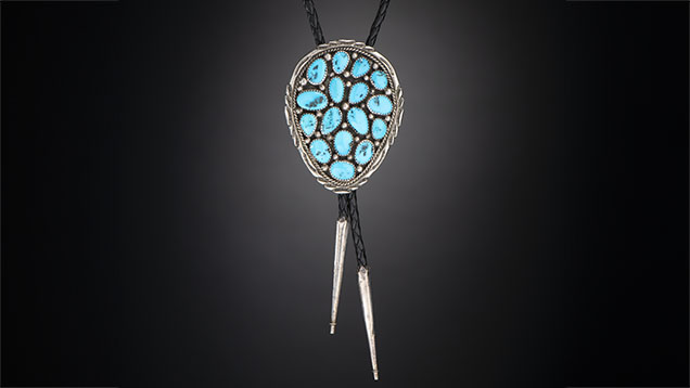 Figure 9. Vintage Navajo silver bolo tie with turquoise reportedly from the Morenci mine in southeastern Arizona, which is not currently being mined for turquoise. This highly collectible material, known for its desirable blue color and iron pyrite matrix, dates back to 1864 and was a byproduct of copper mining. Photo by Kevin Schumacher; courtesy of Aaron Palke. Figure 9. Vintage Navajo silver bolo tie with turquoise reportedly from the Morenci mine in southeastern Arizona, which is not currently being mined for turquoise. This highly collectible material, known for its desirable blue color and iron pyrite matrix, dates back to 1864 and was a byproduct of copper mining. Photo by Kevin Schumacher; courtesy of Aaron Palke.